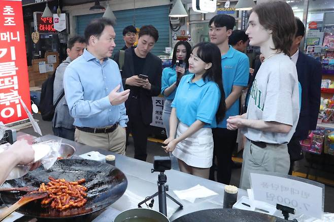 최태원 대한상공회의소 회장(왼쪽)이 지난 17일 서울 통인시장에서 ‘2030 부산엑스포 서포터즈’와 함께 대화를 하고 있다. 대한상의 제공