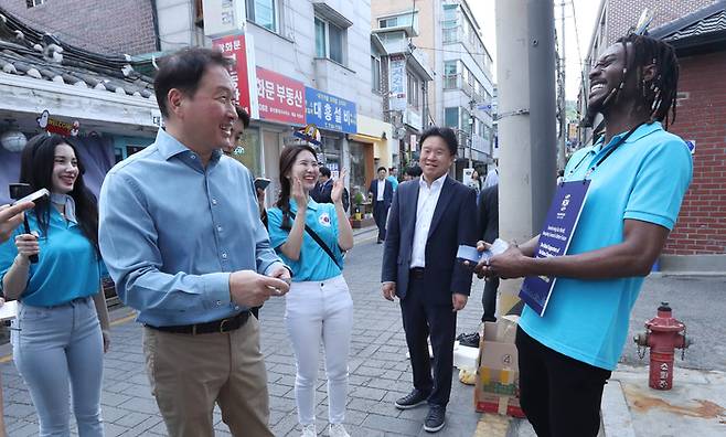 최태원 대한상공회의소 회장(왼쪽 둘째)이 17일 오후 서울 통인시장에서 부산엑스포 서포터즈와 함께 시민들을 만나고 있다. <대한상의>