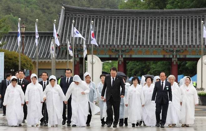 [광주=뉴시스] 홍효식 기자 = 윤석열 대통령이 18일 광주 북구 국립5·18민주묘지에서 열린 제43주년 5·18민주화운동 기념식에 오월어머니회 회원들과 함께 입장하고 있다. (대통령실통신사진기자단) 2023.05.18.