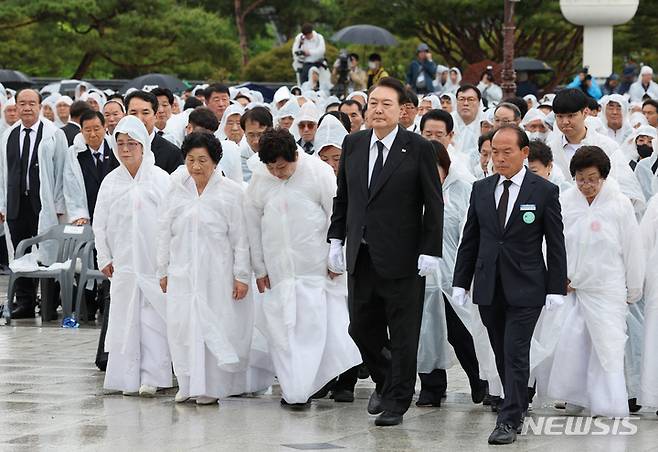 [광주=뉴시스] 홍효식 기자 = 윤석열 대통령이 18일 광주 북구 국립5·18민주묘지에서 열린 제43주년 5·18민주화운동 기념식에 오월어머니회 회원들과 함께 입장하고 있다. (대통령실통신사진기자단) 2023.05.18. yesphoto@newsis.com