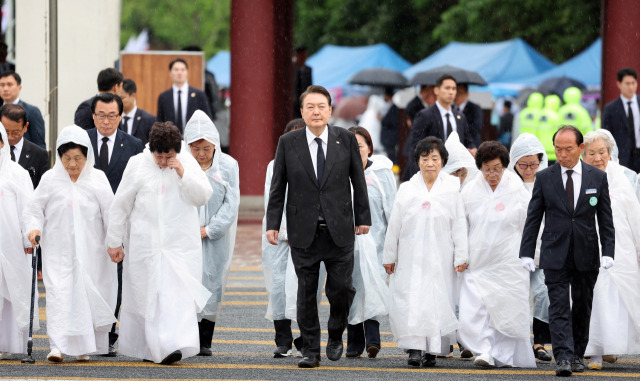 윤석열 대통령이 18일 광주 북구 국립5·18민주묘지에서 열린 제43주년 5·18민주화운동 기념식에 참석하기 위해 오월의 어머니들과 함께 입장하고 있다. / 연합뉴스