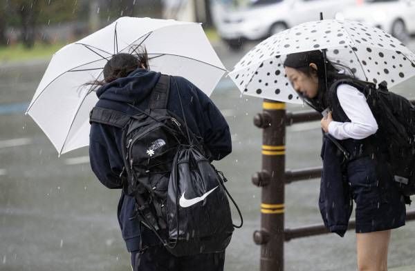 부산 연제구 한 교차로에서 시민이 우산을 쓴 채 힘겹게 이동하고 있다. 국제신문DB