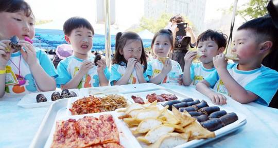 2015년 당시 인천 남동구 인천시청 앞 미래광장에서 열린 북한음식 체험행사에서 아이들이 북한 음식을 맛보는 모습. 전시 음식들 중 가운데 노란색이 두부밥이다. 연합뉴스