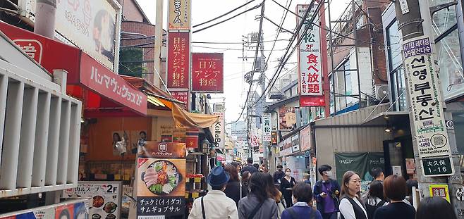 지난 13일 일본 도쿄 최대 한인타운인 신오쿠보 방문객들이 많이 찾는 거리 중 하나인 이케멘거리 풍경. 비가 오락가락하는 흐린 날씨에도 카페와 음식점 앞 대기줄과 지나다니는 인파로 거리는 발 디딜 틈 없이 붐볐다. 손미정 기자