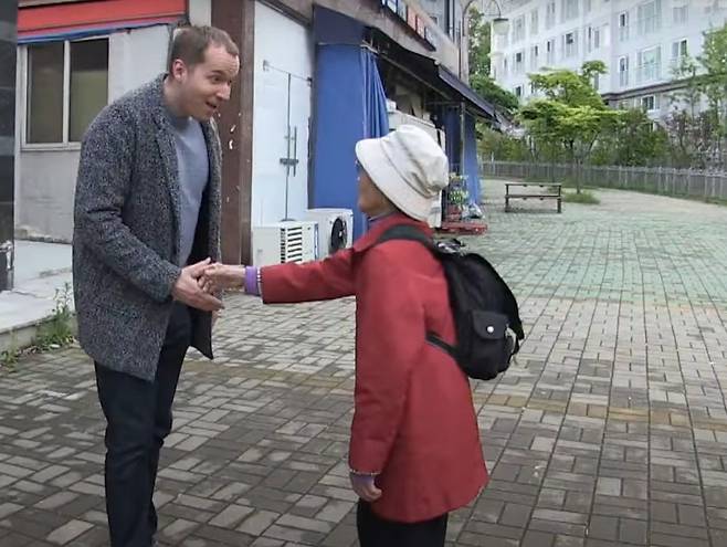 90세 할머니(오른쪽)가 영어 대화를 위해 외국인과 악수하는 모습. /사진=유튜브 캡처