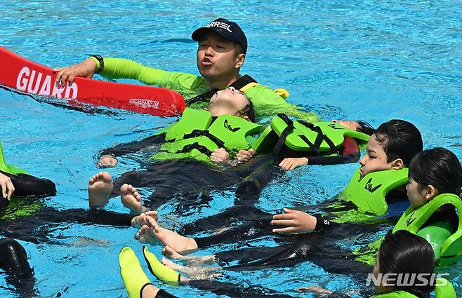 [시흥=뉴시스] 김종택 기자 = 22일 경기도 시흥시 정왕동 거북섬 웨이브파크 파도 풀에서 학생들이 생존수영 실기교육을 받고 있다. 2023.05.22. jtk@newsis.com