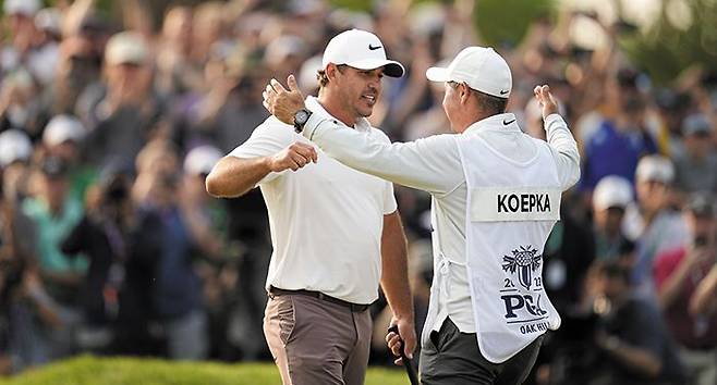 브룩스 켑카(왼쪽)가 22일 미국 오크힐 컨트리클럽에서 열린 PGA 챔피언십에서 우승한 뒤 캐디 리키 엘리엇과 함께 기뻐하고 있다. ‘메이저 사냥꾼’이라 불리는 그의 다섯 번째 메이저 대회 우승이었다. /AP 연합뉴스