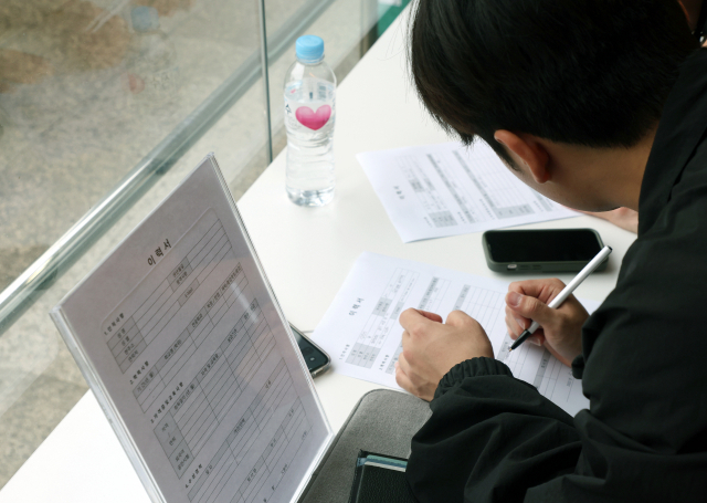 22일 오후 부산 한 대학교에서 열린 취업박람회에서 취업준비생들이 이력서를 쓰고 있다. 연합뉴스