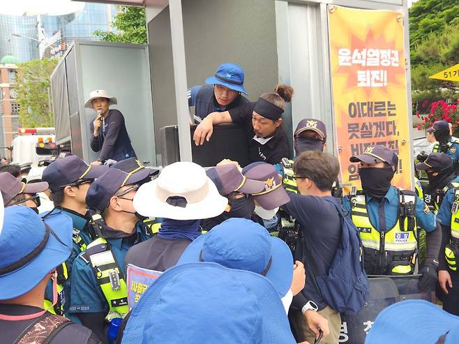 25일 오후 서울 서초구 대법원 앞에서 경찰이 금속노조 조합원들이 설치한 무대차량을 견인하려 하자 조합원들이 저지하고 있다. / 신지인 기자