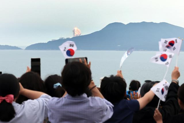 25일 오후 전남 고흥군 영남면 우주발사전망대에서 시민들이 우주로 향하는 누리호를 지켜보면서 태극기를 흔들고 있다. 고흥=연합뉴스