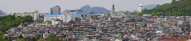 이태원 부군당 역사공원 전망대에서 내려다본 해방촌 일대 주택가 모습. 빽빽하게 주택이 들어선 능선 너머에서 인왕산이 동네를 기웃거리는 듯하다. 마을 신을 모시는 신당인 이태원 부군당은 자체로도 흥미롭지만 그 앞에서 펼쳐지는 장쾌한 전망이 더해져 ‘이태원의 명소’라 할 수 있는 곳이다.