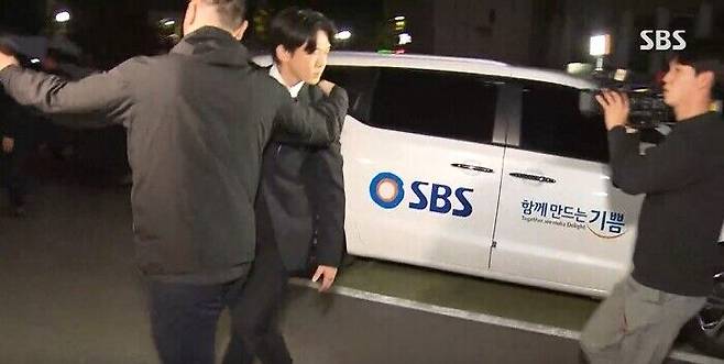 배우 유아인, 날아든 커피잔에 표정을 찡그리는 모습. (사진=SBS 보도 화면 캡쳐)