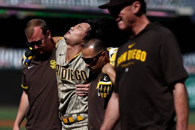 김하성이 트레이너 2명의 부축을 받고 더그아웃으로 들어가고 있다. 맨 오른쪽이 밥 멜빈 감독이다. 멜빈 감독은 김하성이 타구에 맞는 순간 가장 먼저 나갔다. AFP연합뉴스