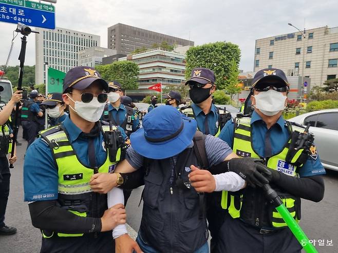 25일 대법원 동문 앞 도로에서 무대차량 견인을 방해하던 조합원이 경찰에 연행되고 있다. 주현우기자 woojoo@donga.com