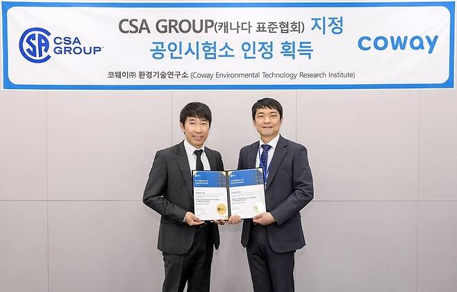 지경철 코웨이 환경기술연구소 TQA실장(왼쪽)과 양대석 CSA그룹 한국 지사장이 ‘CSA그룹 지정 시험소’ 인증서를 들어 보이고 있다.