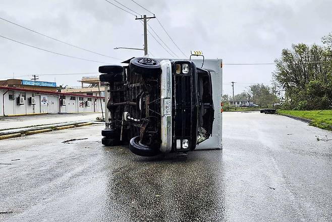 슈퍼태풍 ‘마와르’가 강타한 태평양 섬 괌의 한 고속도로에서 25일(현지시간) 트럭이 전복돼 있다. AP연합뉴스