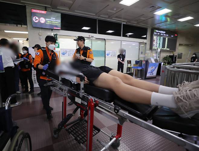 공항서 병원으로 긴급 이송 26일 제주공항을 출발해 대구공항으로 향하던 아시아나항공 여객기에서 착륙 직전 출입문이 열린 사고가 난 후 호흡곤란을 느낀 한 탑승객이 들것에 실려 나오고 있다. 연합뉴스