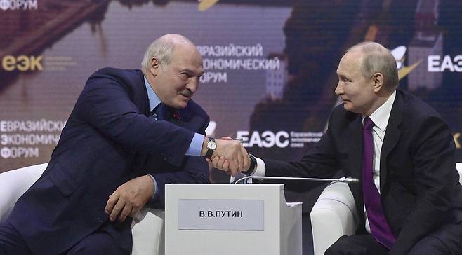 유라시아경제연합(EAEU) 포럼 참석을 위해 러시아 모스크바를 방문한 알렉산드르 루카셴코 벨라루스 대통령(왼쪽)이 24일(현지시간) 블라디미르 푸틴 러시아 대통령과 악수하고 있다.  EPA연합뉴스