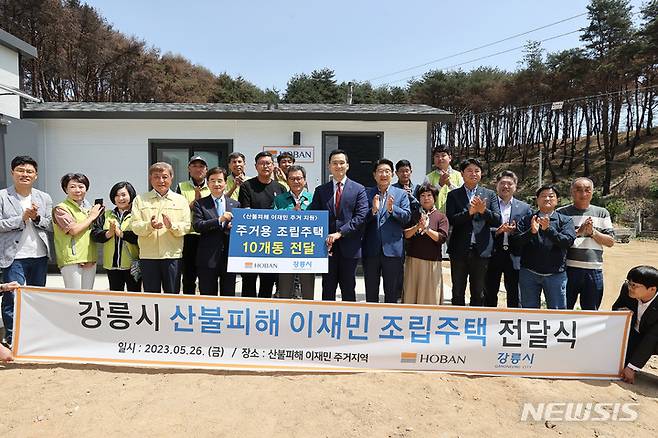 [서울=뉴시스] 호반그룹이 산불로 인해 특별재난지역으로 선포된 강릉시에 임시 조립주택을 전달했다. 앞줄 왼쪽에서 네 번째 김기영 강릉시의장, 다섯 번째 김선규 호반그룹 회장, 여섯 번째 김홍규 강릉시장, 일곱 번 째 김대헌 호반그룹 기획총괄사장, 여덟 번째 권성동 국민의힘 의원. (사진=호반그룹 제공)