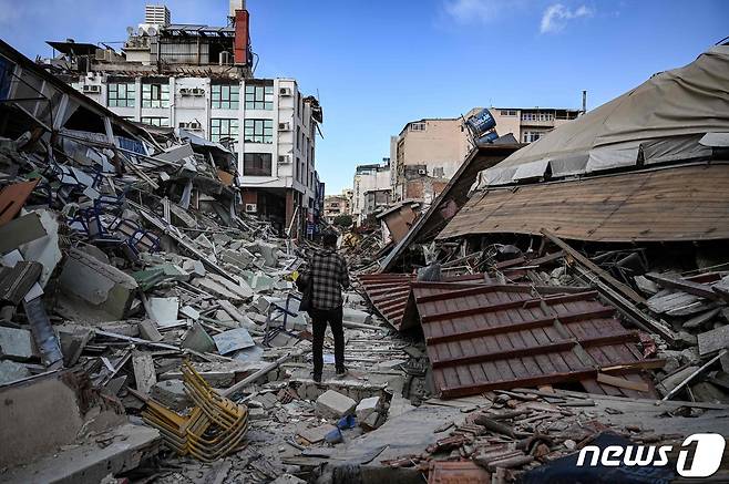 지진 발생 한 달을 맞은 6일(현지시간) 튀르키예 남부 하타이에서 한 남성이 무너진 건물 잔해 사이를 걸어가고 있다. 지난달 6일 발생한 규모 7.8의 강진으로 튀르키예와 시리아에서 5만명 넘게 사망했다. 무너진 건물은 약 21만채로 집계됐다. 2023.03.06. ⓒ AFP=뉴스1 ⓒ News1 김성식 기자