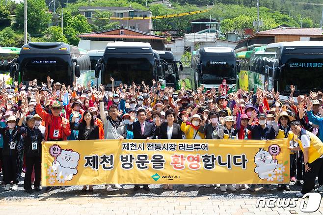 제천시가 역점적으로 추진하는 전통시장 러브투어 참가 관광객을 김창규 제천시장과 이정임 시의회 의장이 맞이 하고 있다.