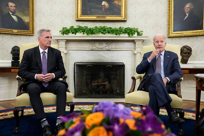 조 바이든 대통령(오른쪽)과 케빈 매카시 하원의장이 지난 22일(현지 시각) 연방정부 부채한도 협상을 위해 백악관 집무실에 나란히 앉았다. /연합뉴스