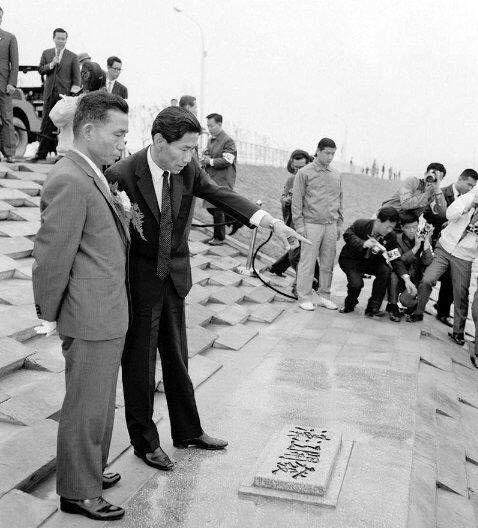 서울시는 도심지역의 주택난 해결을 위해 여의도에 신도시를 짓기로 하고, 홍수 때마다 물에 잠기는 여의도의 문제 해결을 위해 제방(윤중제)를 설치해  택지를 조성했다.  사진은 윤중제 준공식에 참석한 빅정희 대통령(왼쪽)이 한강개발이라고 쓰인 표지석 앞에서 김현옥 당시 서울시장으로부터 설명을 듣는 모습이다. 국가기록원 제공