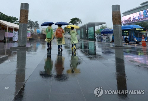 우중 완전 무장    부처님 오신 날 연휴를 맞아 빗줄기가 이어지는 가운데 28일 서울 세종대로 광화문광장에서 우산을 들고 우비를 착용한 시민들이 오가고 있다. [연합뉴스]