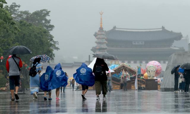 전국에 비가 내리는 가운데 28일 서울 세종대로 광화문광장에서 우산을 쓰거나 우비를 입은 시민들이 연휴를 즐기고 있다.