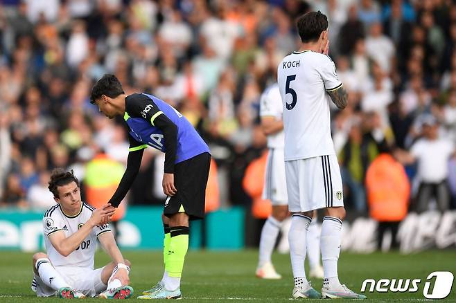 좌절하고 있는 리즈 선수를 일으켜주고 있는 손흥민. ⓒ AFP=뉴스1