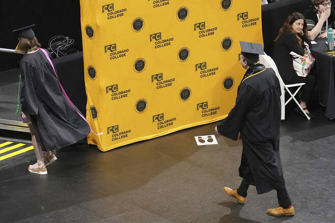 28일(현지시각) 리즈 체니 전 하원의원이 콜로라도 대학에서 졸업축사연설을 하는 도중 몇 학생들이 식장을 떠나고 있다. AP 연합뉴스