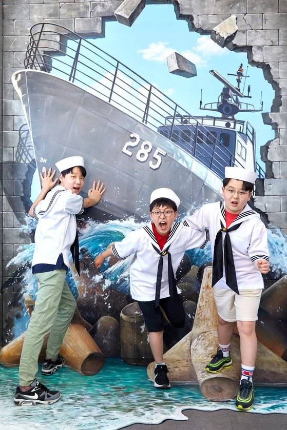 심예준·명운서·최세현(왼쪽부터) 학생기자가 서울함공원 안내센터 1층에 있는 참수리급 고속정을 배경으로 한 포토존에서 포즈를 취했다.