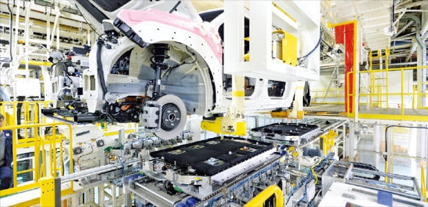 지난 25일 기아 오토랜드 광명 1공장의 전기차 생산라인에서 ‘고전압 배터리 체결 로봇’이 EV9 차체와 배터리 결합 작업을 하고 있다. 기아 제공