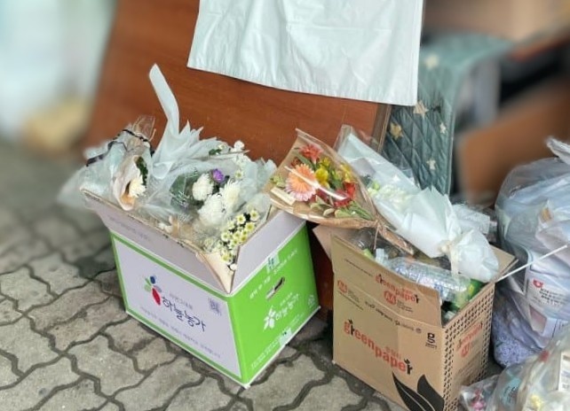 학교 폭력을 호소하는 글을 남기고 숨진 고 김상연군의 모교에 시민들이 자발적으로 놓안 둔 추모 꽃이 쓰레기장에 버려져 있는 모습. (독자 제공) /뉴스1
