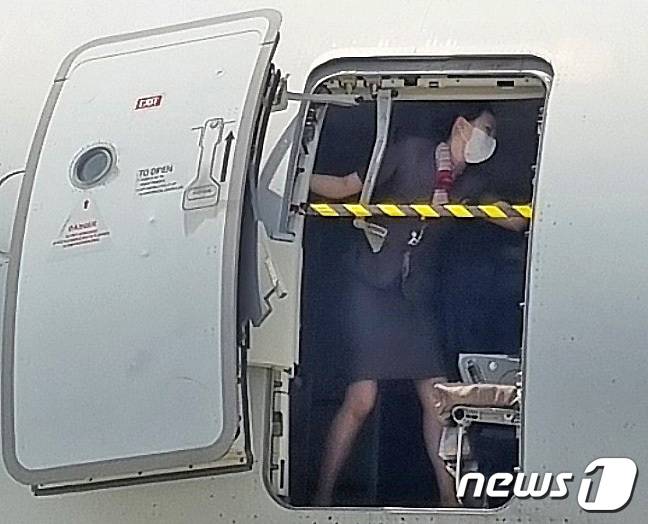 지난 26일 제주에서 출발해 대구로 향하던 아시아나항공기에 탑승한 30대 남성 A씨가 대구공항 상공에서 비상문을 강제로 개방해 승객들을 공포에 떨게 한 가운데 승무원이 비상문을 온몸으로 막고 있는 사진이 확보됐다. 익명을 요구한 한 시민은 "항공기 비상문이 열린 상황에서 여성 승무원이 두 팔을 벌려 입구를 몸으로 막고 있었다＂고 전했다. (독자 제공) 2023.5.28/뉴스1 ⓒ News1 공정식 기자