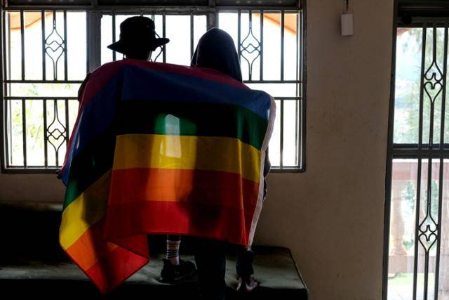 우간다 의회가 2일 성소수자(LGBTQ) 처벌 강화 법안을 일부 수정해 통과시키고 요웨리 무세베니 우간다 대통령이 29일 법안에 서명해 미국 등 국제사회의 비판이 쏟아지고 있다. 사진은 지난달 25일 우간다에서 한 게이 커플이 무지개 깃발을 들고 있는 모습. 우간다=AP 연합뉴스