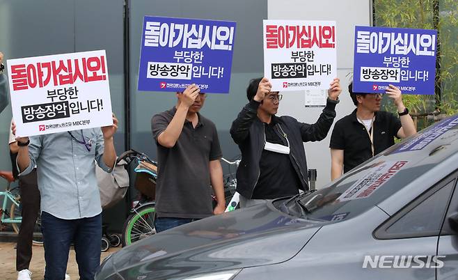 [서울=뉴시스] 권창회 기자 = 경찰이 한동훈 법무부 장관의 개인정보가 담긴 문건 유출 과정에 MBC 기자가 관여한 것으로 의심하고 해당 기자와 MBC, 국회사무처에 대한 압수수색에 나섰다. 경찰은 MBC 본사로 찾아왔지만 언론노조 등에 막혀 결국 철수했다. 사진은 30일 오후 서울 마포구 상암MBC에서 언론노조 조합원이 철수하는 경찰차량에 손피켓을 든 모습. 2023.05.30. kch0523@newsis.com