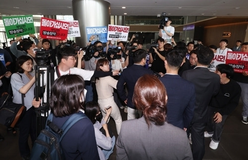 한동훈 법무부 장관의 개인정보 유출 의혹과 관련해 MBC 기자 임모씨를 압수수색 중인 경찰이 30일 상암동 MBC 사옥 진입을 시도하자 노조원들이 이에 항의하고 있다.  연합뉴스