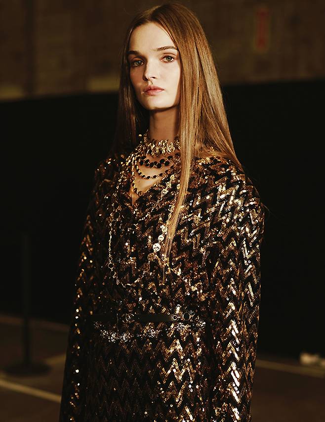 블랙 앤 골드 시퀸 장식의 드레스와 과감한 네크리스 레이어드는 룩에 무게감을 더한다.