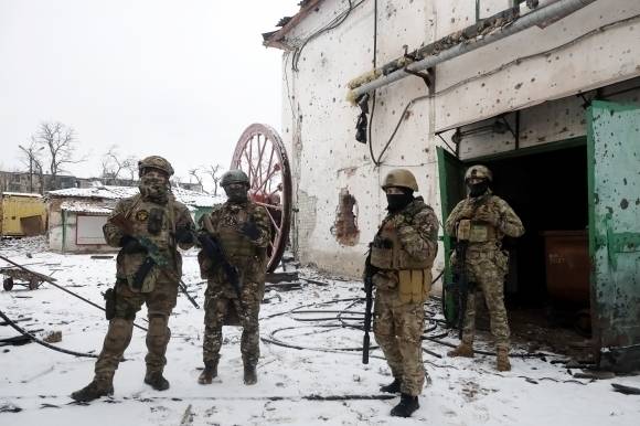 러시아 민간군사기업(PMC) 바그너그룹 용병들이 우크라이나 동부 돈바스 도네츠크 솔레다르에서 집중 포화로 파괴된 건물 밖에 서 있다. TASS 연합뉴스