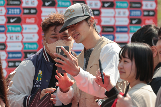 Cho Gue-sung, center, takes a picture with fans ahead of a Korean national team training session at Paju National Football Center in Paju, Gyeonggi on March 20. [YONHAP]
