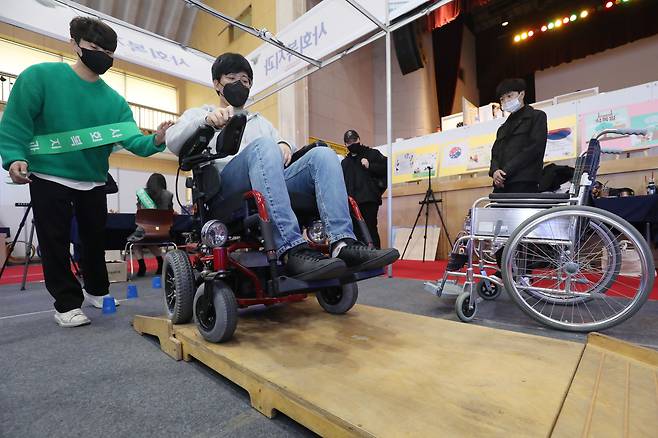 대구 북구 영진전문대 백호체육관에서 열린 ‘2022 영진종합작품전’에서 사회복지과 학생들이 경사로 휠체어 체험을 돕고 있다. 주문식 교육을 통해 성장한 학생들의 실력을 선보이는 이번 작품전은 코로나19 확산 여파로 3년 만에 재개됐다. 산학연계 프로젝트로 진행한 기발한 작품과 공모전 입상작 등이 60개 부스에서 선보이고, 공연과 발표회도 잇따라 열린다. 2022.10.27/뉴스1
