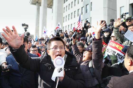 자유한국당(국민의힘의 전신) 황교안 전 대표가 2019년 12월 16일 서울 여의도 국회에서 열린 '공수처법 선거법 날치기 저지 규탄대회' 참가자들과 함께 시위를 벌이고 있다.  이들은 본청 무단 진입을 시도하다 경찰에 막혀 입구에서 집회를 열었다. 연합뉴스