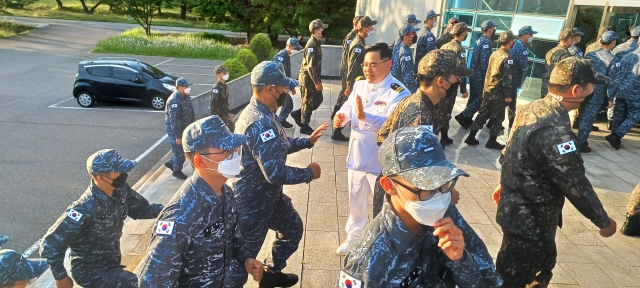 해군교육사교회 김상혁 목사가 세례식에 참석하는 훈련병들을 반갑게 맞이하며 하이파이브를 나누고 있다.