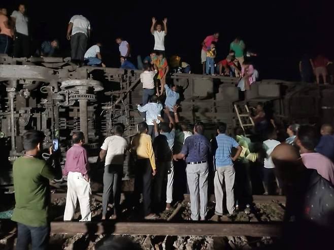 6월 2일 인도 동부 오디샤주 발라소르 지역에서 발생한 열차 충돌 사고 현장에서 사람들이 생존자를 구조하고 있다./신화 연합뉴스