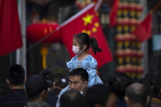 [베이징=AP/뉴시스]지난 10월 7일 베이징 도심에서 한 남성이 여자아이를 목마를 태우고 가고 있다. 2023.01.17 /사진=뉴시스
