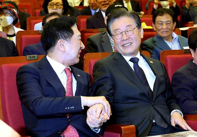 국민의힘 김기현 대표(왼쪽)와 더불어민주당 이재명 대표가 지난달 22일 오전 국회에서 열린 민주화추진협의회 결성 39주년 기념식에서 대화하며 서로의 손을 포개어 잡고 있다. [사진 = 연합뉴스]