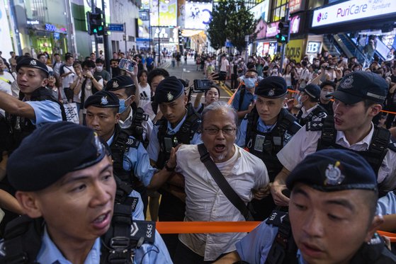 3일 홍콩 번화가 코즈웨이 베이에서 경찰이 천안문 34주기를 추모하려던 시민을 연행하고 있다. AP=연합뉴스