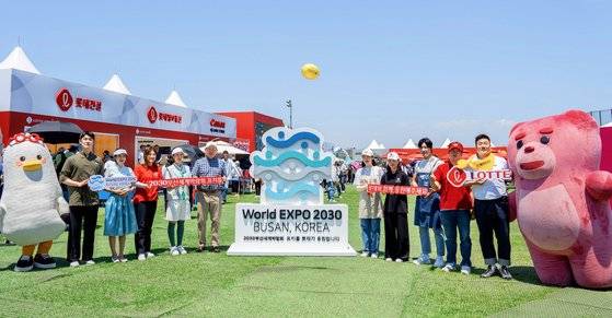 신동빈 롯데 회장(왼쪽 여섯번째)이 3일 한국여자프로골프(KLPGA)투어 '2023 롯데 오픈' 경기가 열리는 베어즈베스트 청라를 방문해 롯데 오픈 운영 직원, 부산시 대표 캐릭터 부기(왼쪽 첫번째), 롯데홈쇼핑 캐릭터 벨리곰(오른쪽 첫번째)과 함께 2030부산세계박람회 유치를 응원했다. 사진 롯데지주