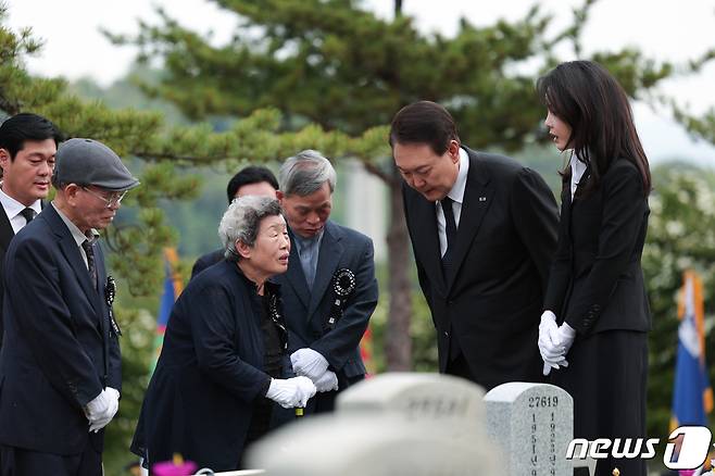 윤석열 대통령과 김건희 여사가 6일 오전 서울 동작구 국립서울현충원 52묘역에서 6‧25전쟁 전사자 故 김봉학 육군 일병의 유해를 안장하는 '호국의 형제' 안장식에 참석해 유가족과 대화하고 있다. 고 김봉학 일병의 유해는 동생인 고 김성학 육군 일병 묘역에 합동 안장됐다. 형제는 6‧25전쟁에 참전한 지 73년 만에 유해로 상봉했다. (대통령실 제공) 2023.6.6/뉴스1 ⓒ News1 안은나 기자